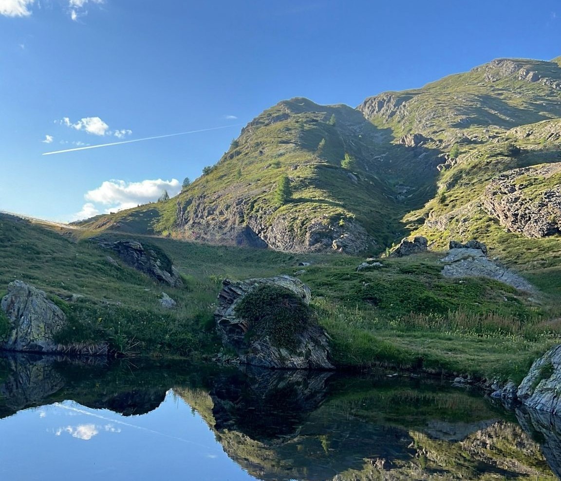 Lago alpino con la montagna riflessa nell'acqua calma